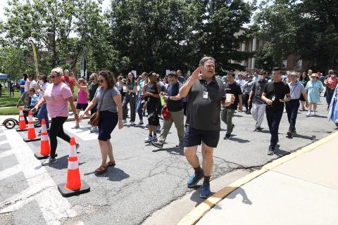 Rows of walkers line up beyind cones in street near Bldg. 1 ready to begin