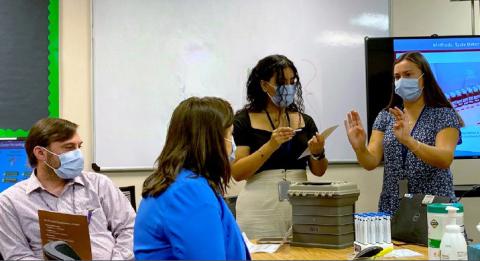 Two postbacs speak in front of a room