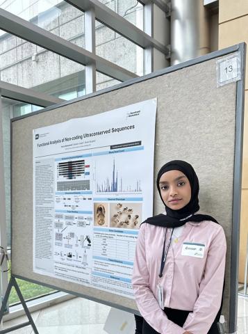 Muhammed stands in front of a scientific poster