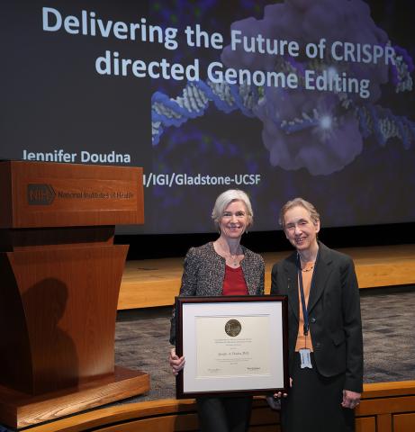 Dounda holds up a plaque standing next to Schor