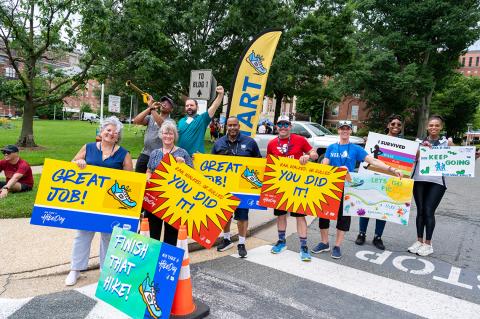 Group of people hold big, bright signs: you did it! Great job! Finish!