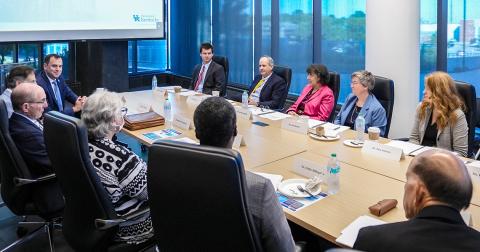 Large conference table with men and women seated around it.