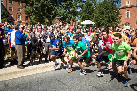 Runners take off from the starting line. Former NIH director Dr. Francis Collins, 2nd from left in the front row, blows a whistle to start the runners.