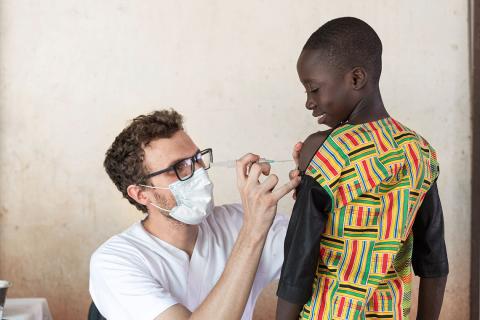 A health care worker administers a vaccine to a child.