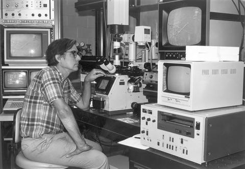 Black and white photo of Reese surrounded by lab equipment