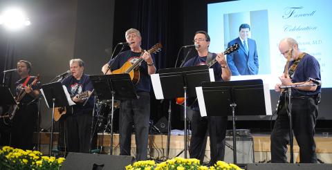 Several people playing guitars and bass on stage