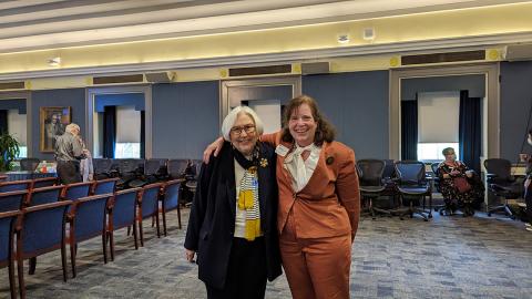 Lyons stands with her arm around Harden. Both are smiling. 