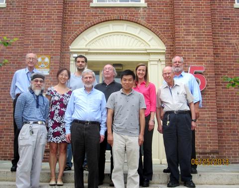 Felsenfeld and labmates pose for a photo outside of a brick building.