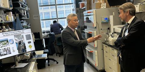 Zhou with outstretched hands animatedly talks with Plescia.