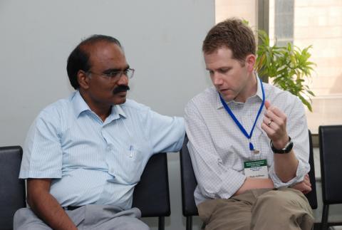 Huffman and Prabhakaran sit together talking.