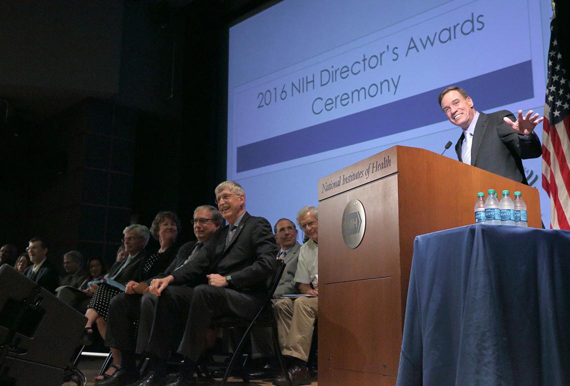 Sen. Warner gestures at podium.