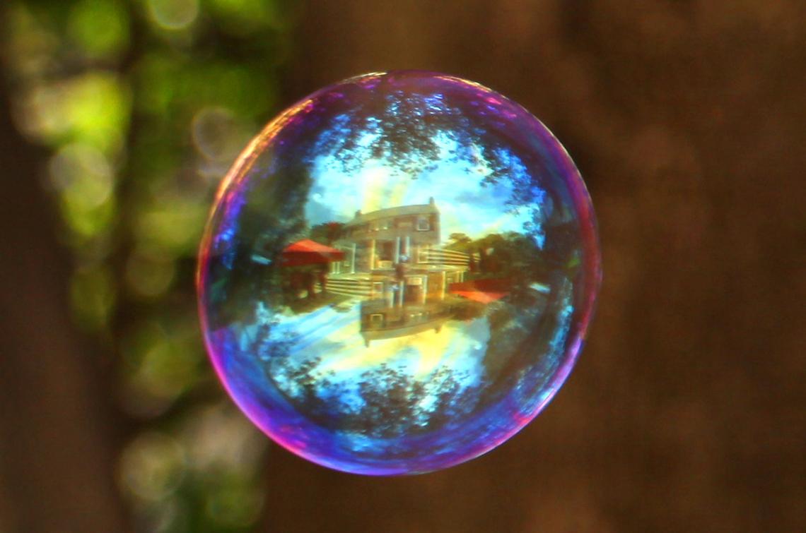 Soap bubble reflects Stone House.