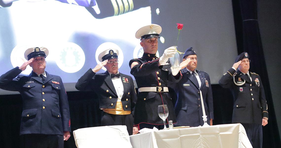 Service members hold their hands to their foreheads in salute.