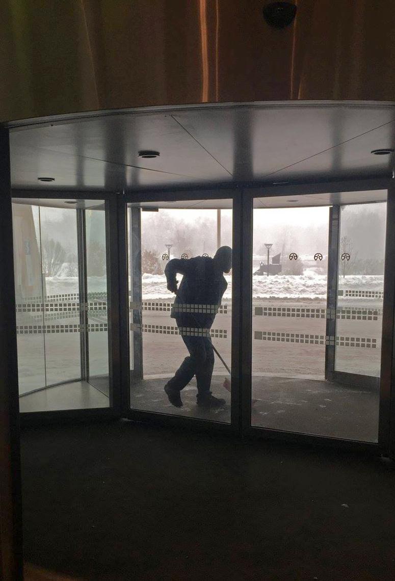 A snow shoveler clears a hospital entrance