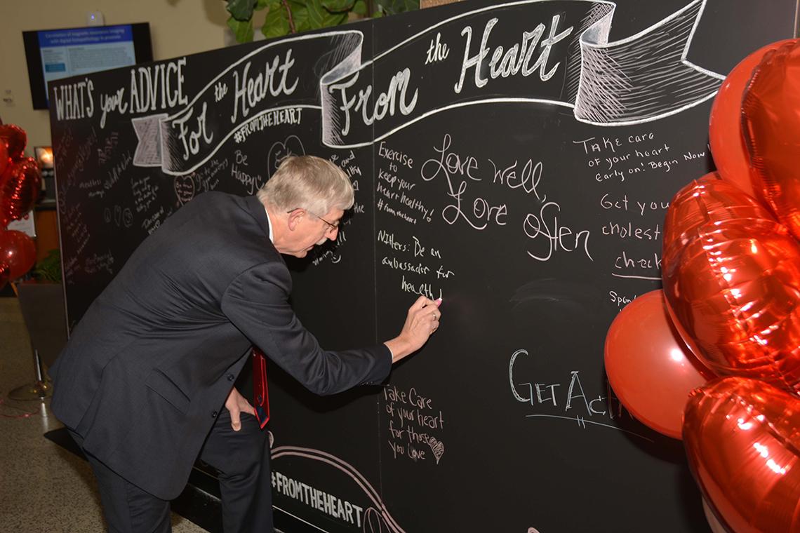 Dr. Collins writes message on blackboard.