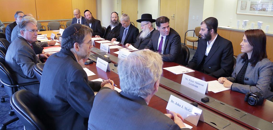 The Israeli delegation and NIH leaders sit around a board room table.