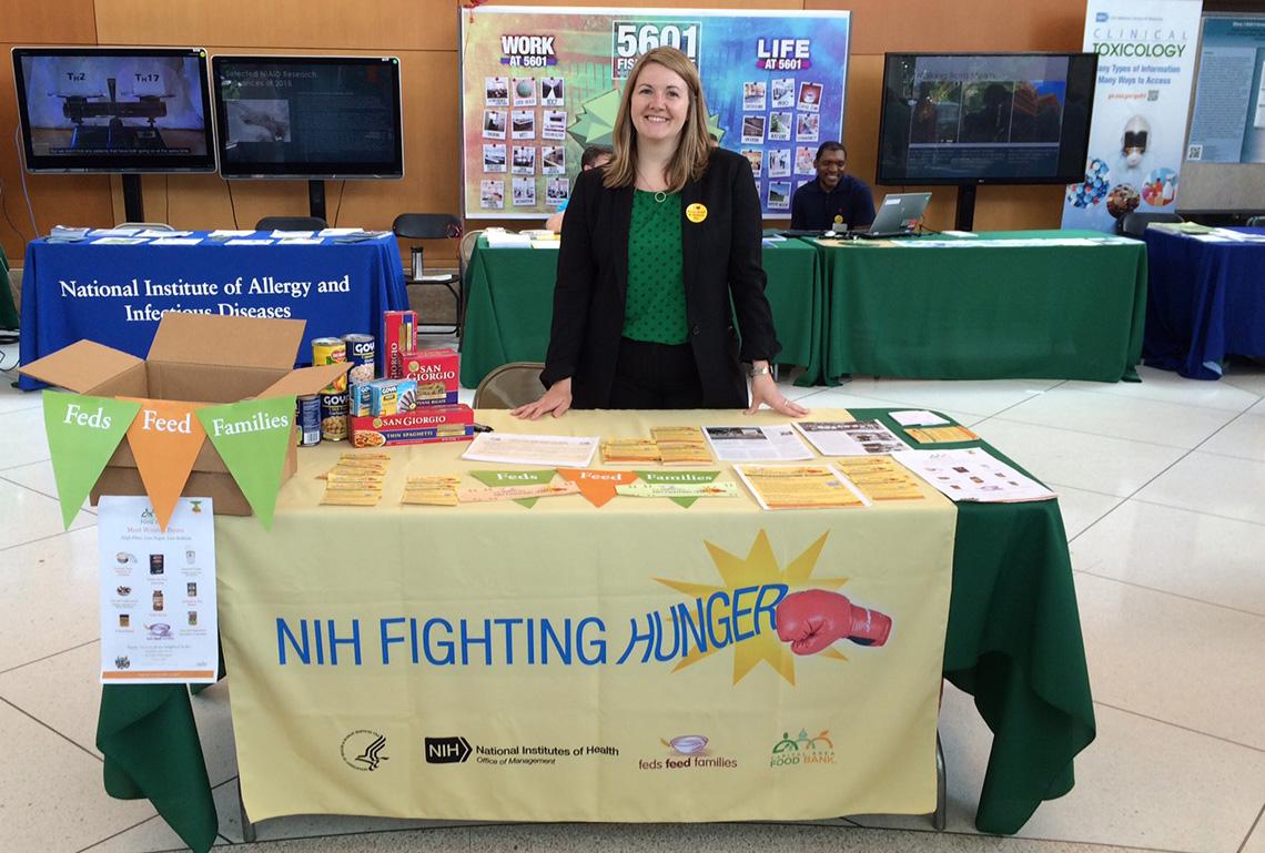 Welcher stands at NIH Fighting Hunger information table in the CC south lobby