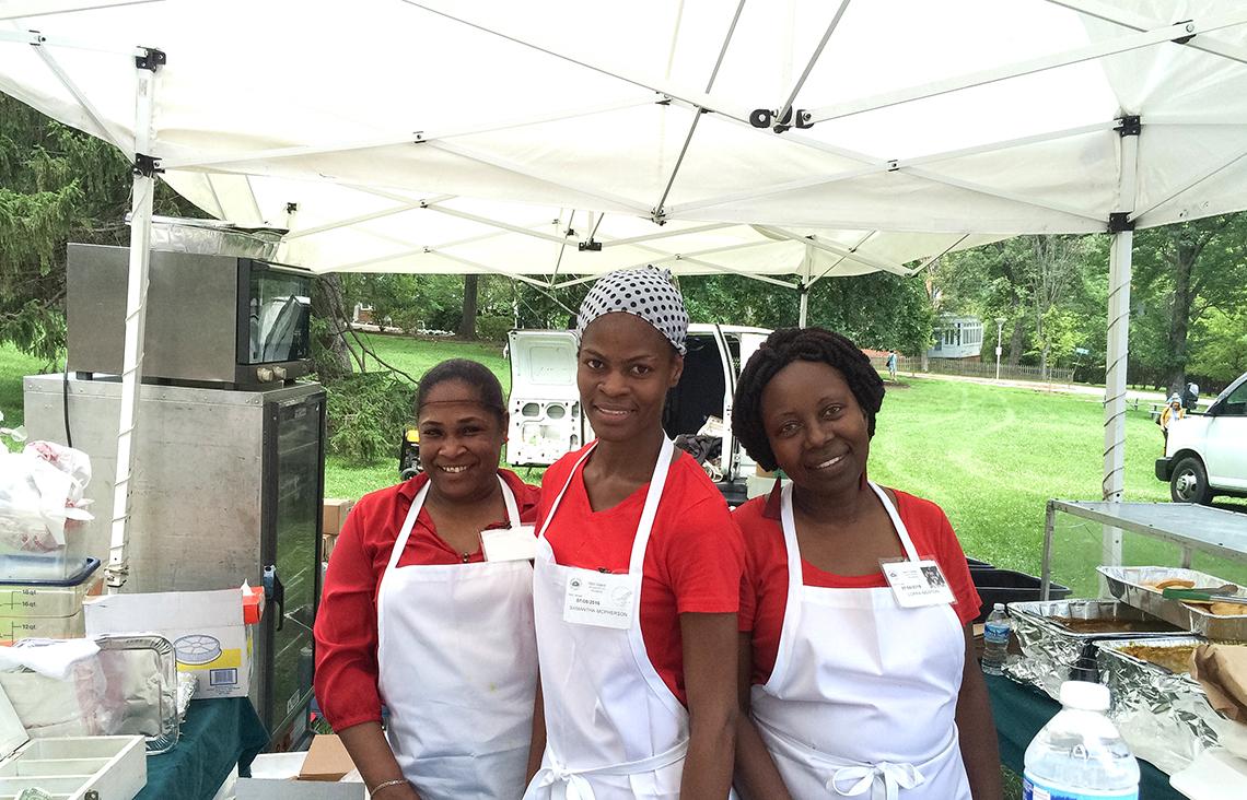 Ladies serve food at event.