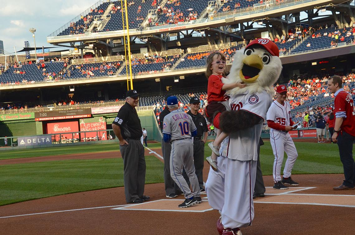 Child with team mascot on field