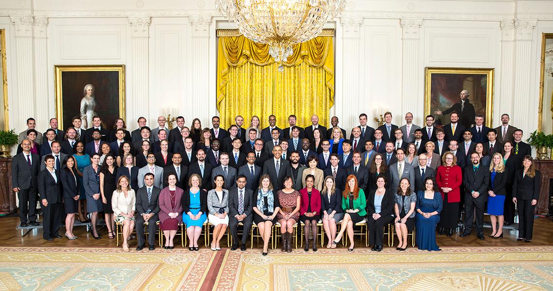 President in large group photo with scientists