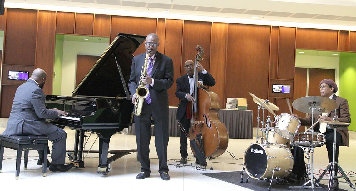 Jazz musicians playing piano, saxophone, upright bass and drums