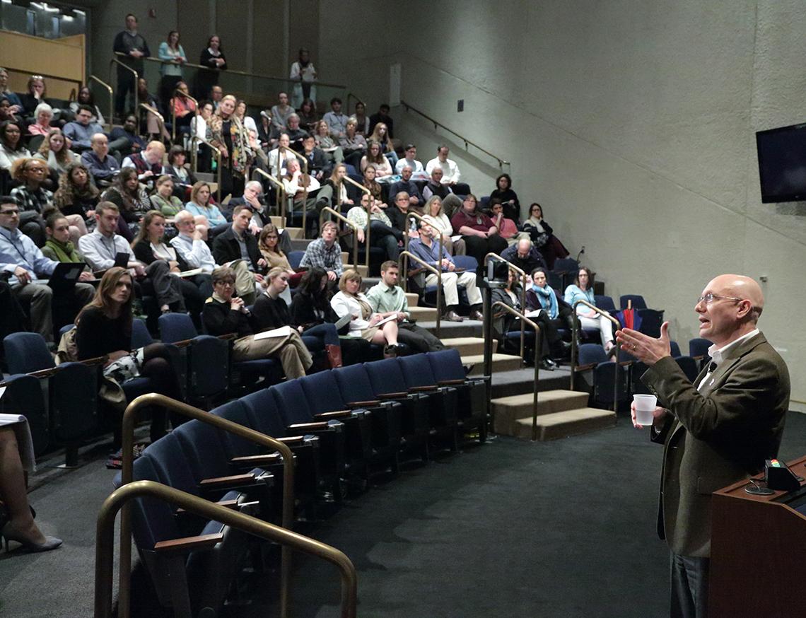 Rosenstein stands talking to audience in Lipsett Amphitheater.