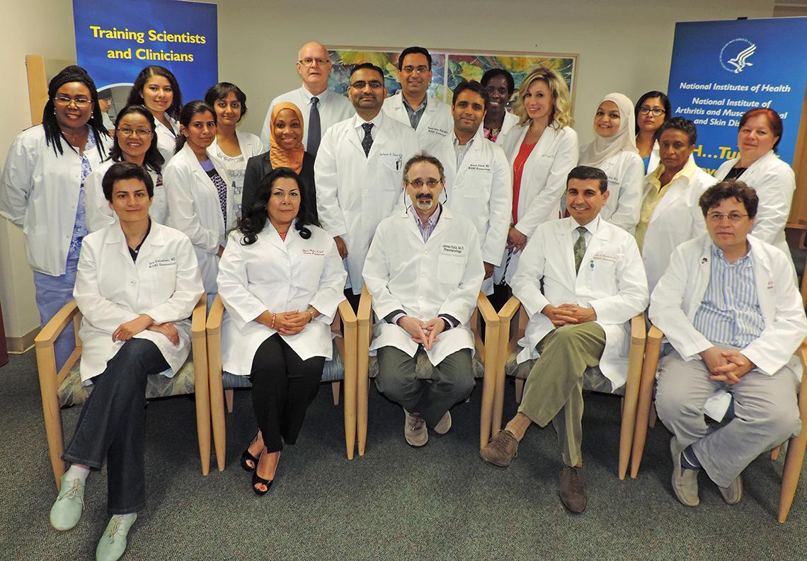 NIAMS staff, all in white lab coats, pose together.