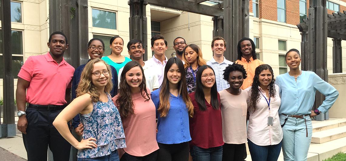 Students pose together outside on the NIH campus.