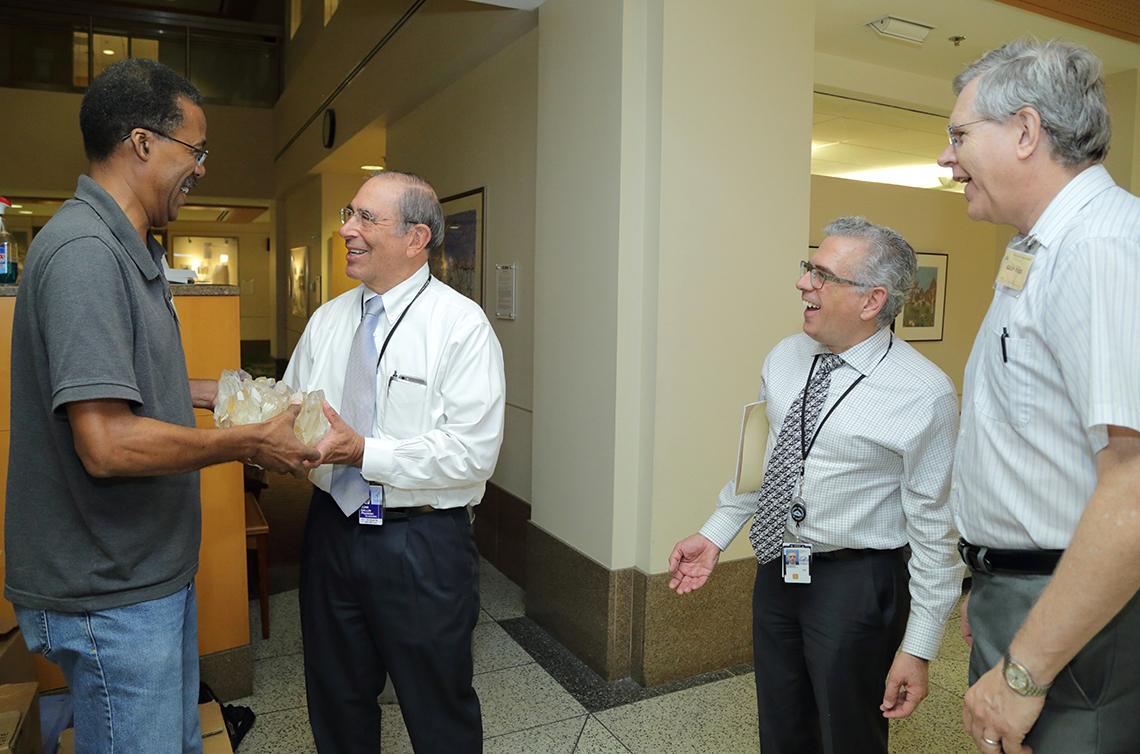 Gallin holds a large gem, handed to him by a Smithsonian geologist as colleagues look on