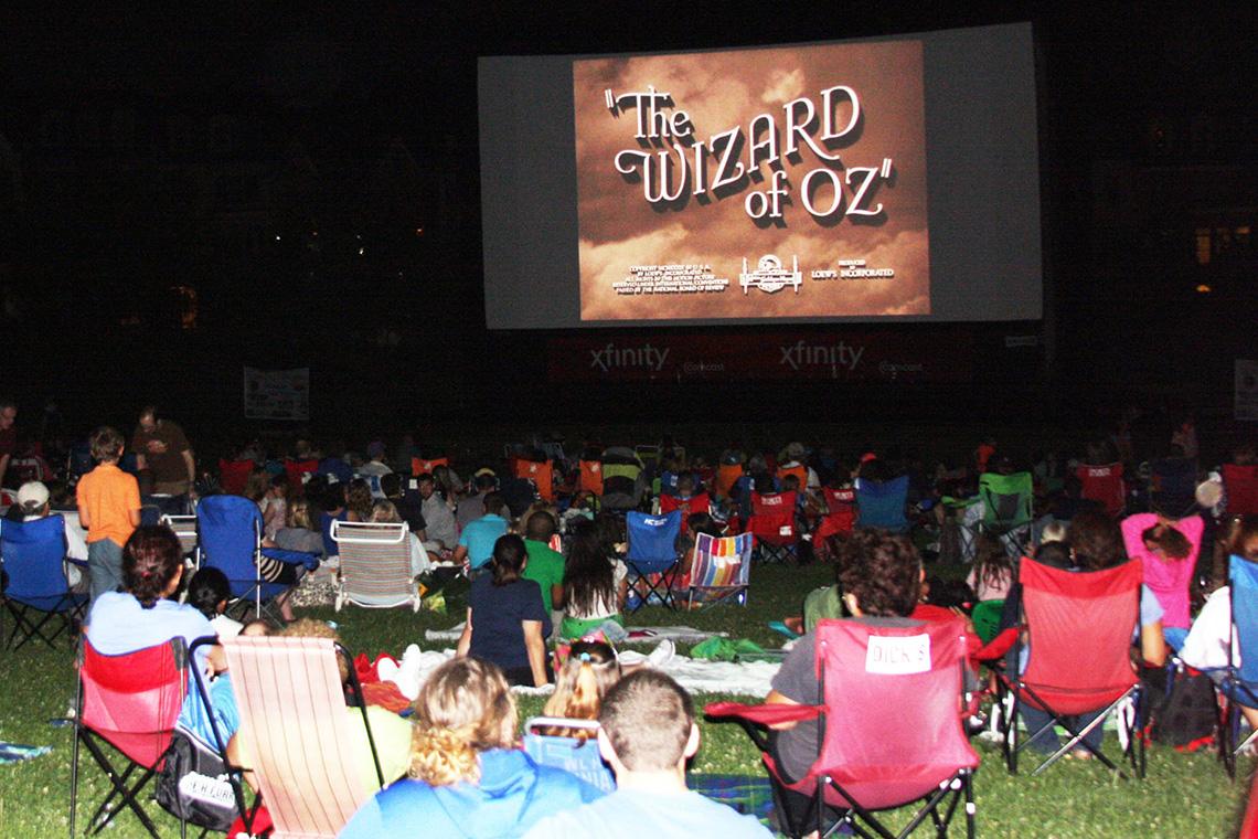 People sit on the lawn watching the Wizard of Oz.