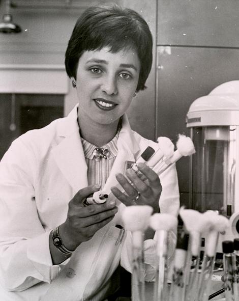 Dr. Maxine Singer holds test tube vials in the lab