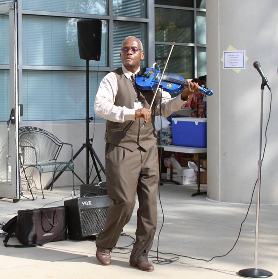 An NIH'er plays violin outside the Clinical Center.