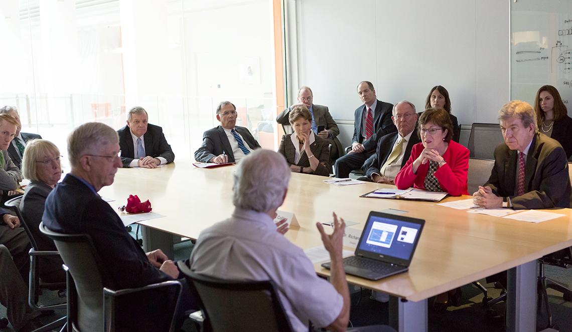 Hodes briefs a group sitting at a conference table