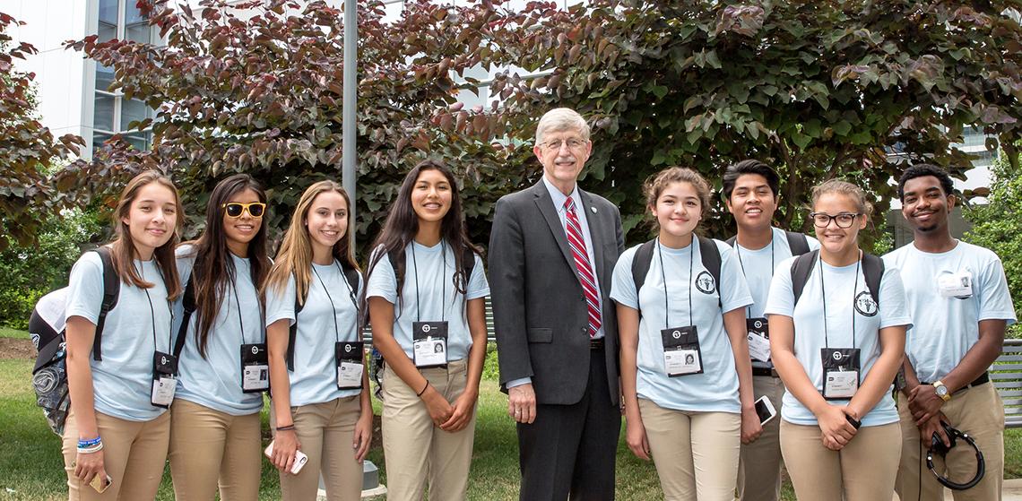 American Indian high school students pose with Dr. Collins outside, on the NIH campus.