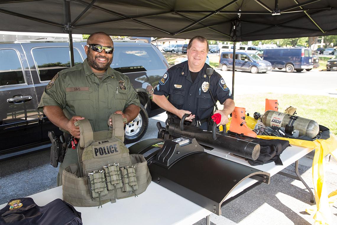Behind a table, Sims and Matney display some tactical gear. 