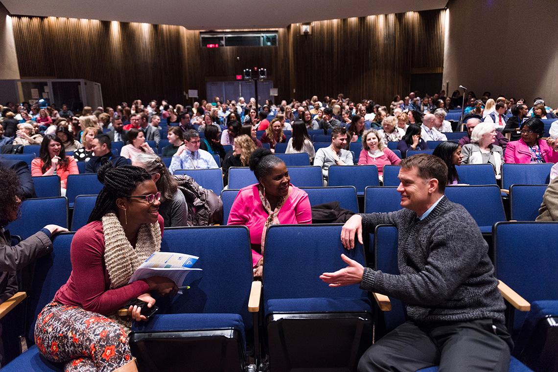 Two members of the audience talk to each other