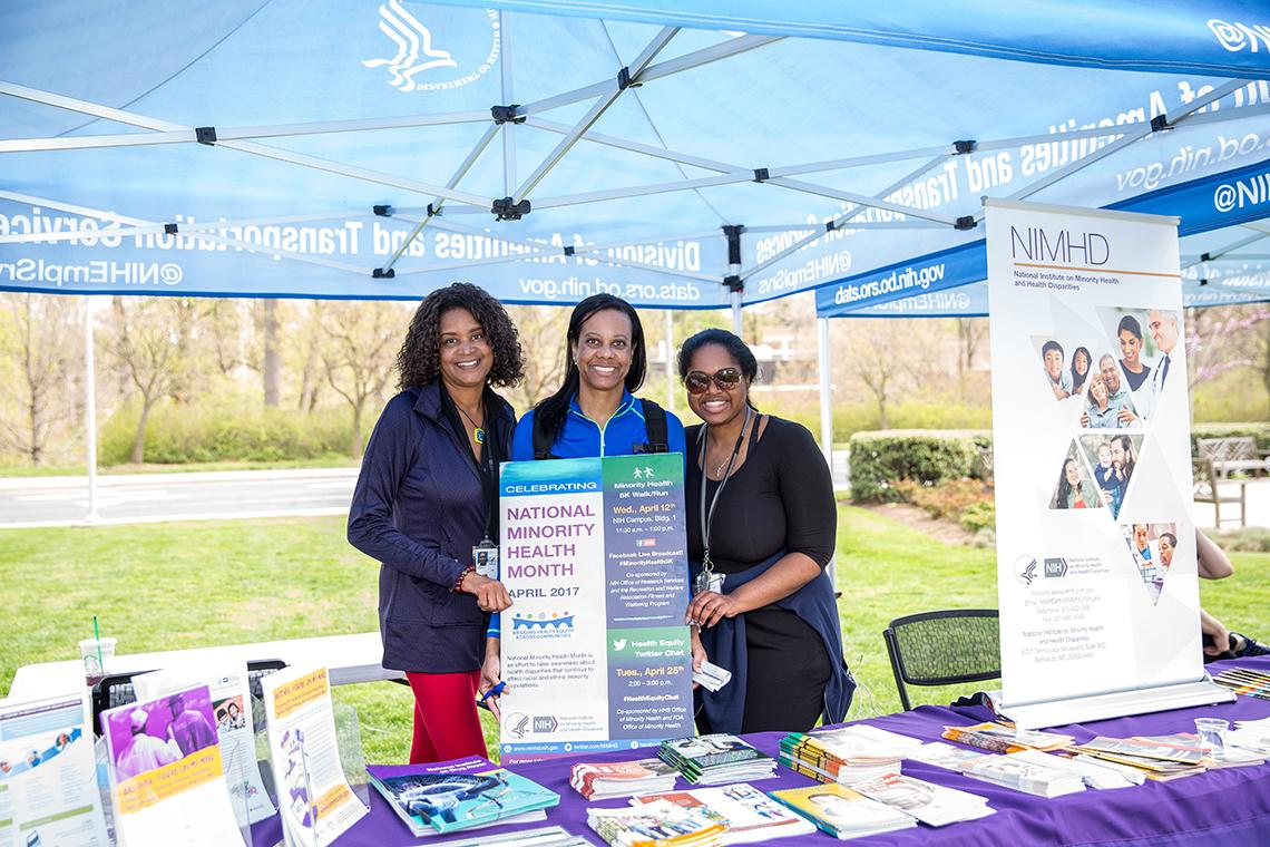 Three employees staff an info booth