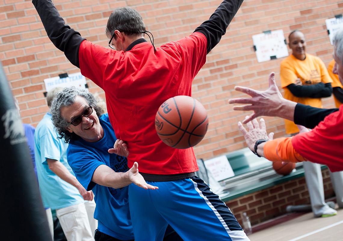 Pérez-Stable reaches around a very tall Hays, who's holding up his arms to block.