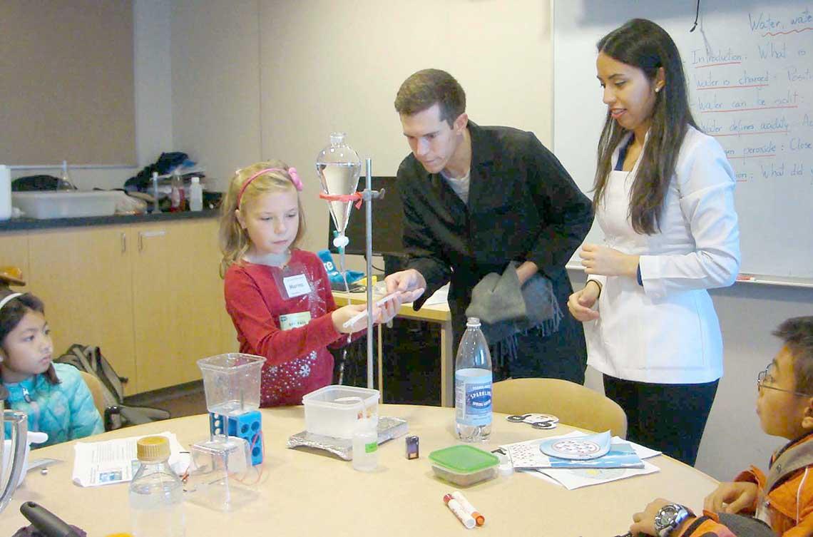 Youngster is guided by adult instructor in science experiment