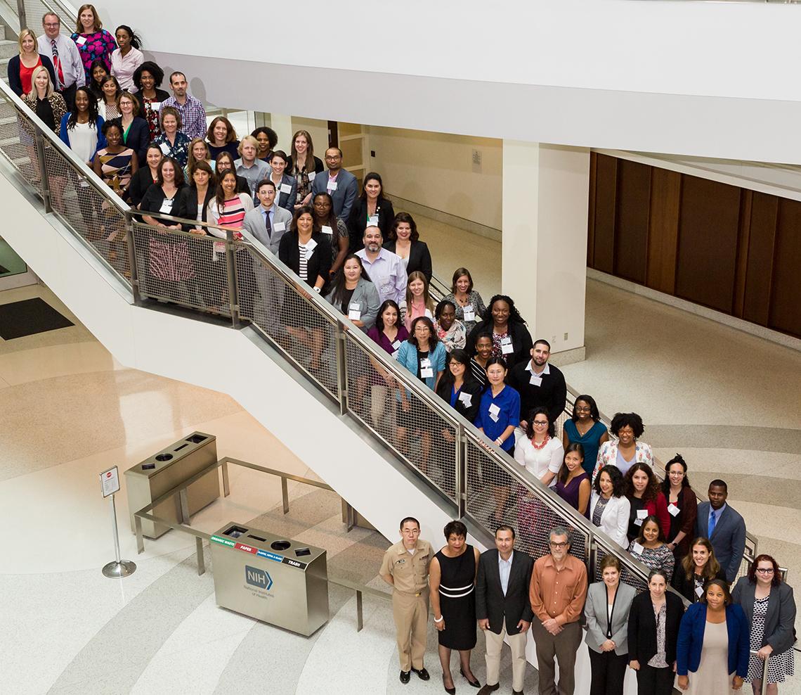 Dozens of NIMHD research scholars pose for photo along a staircase.
