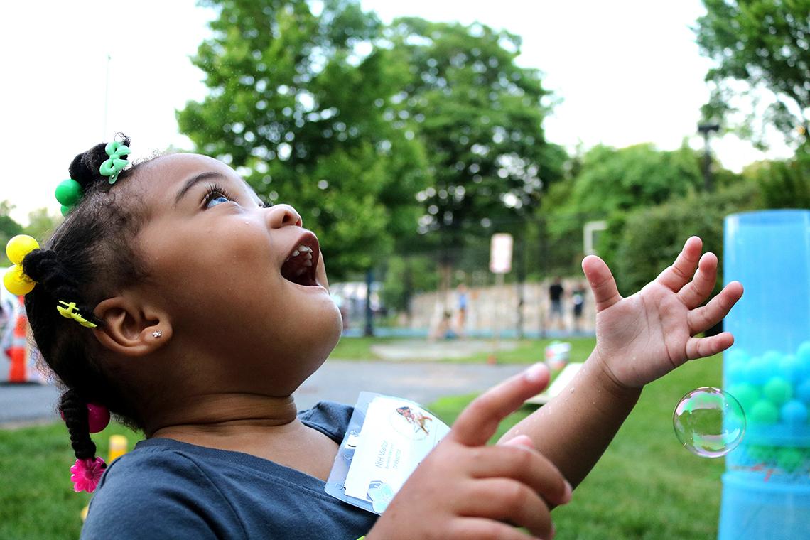 Cyntana Thomas marvels at bubbles as they float through the air.
