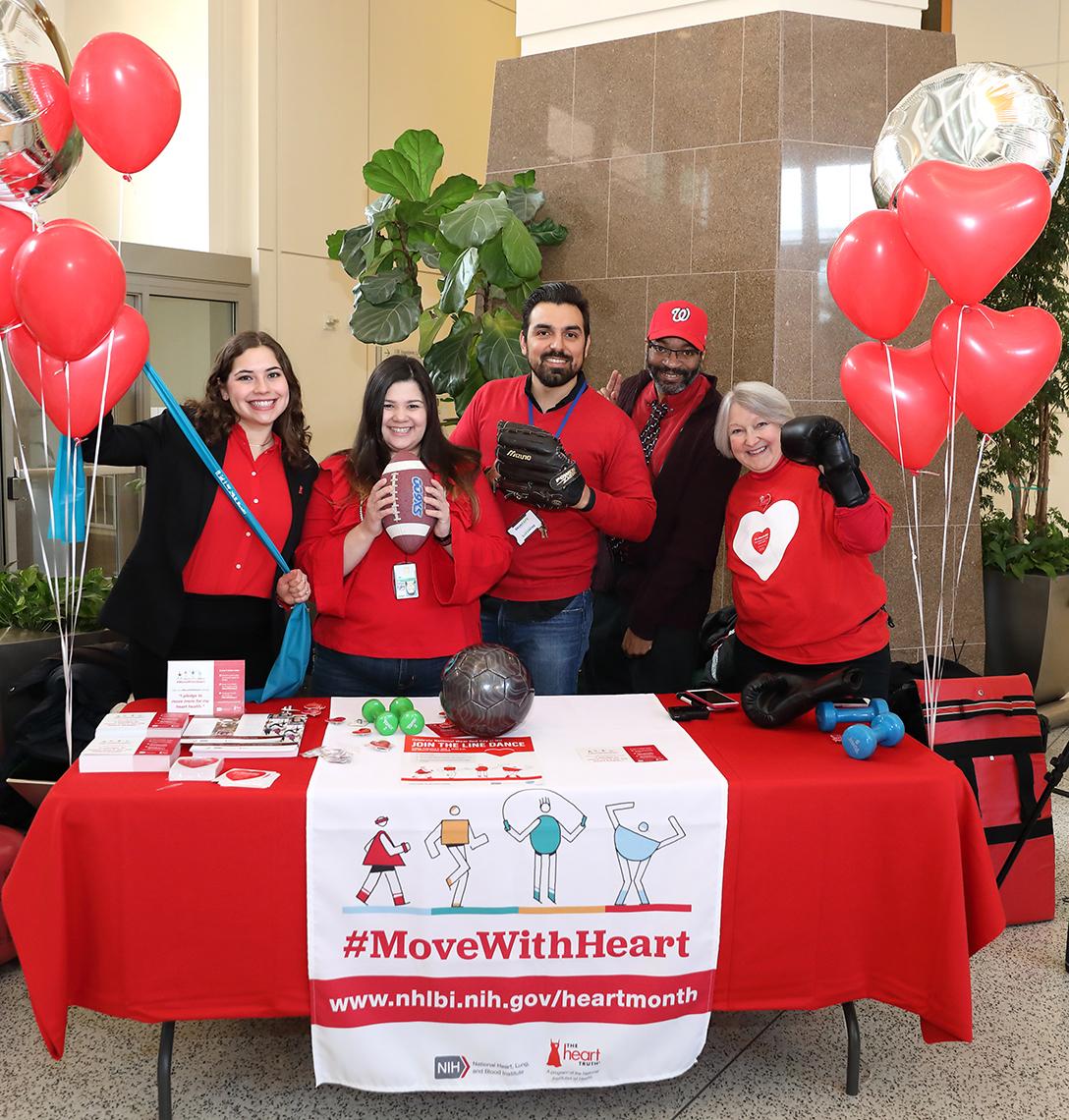 Wear Red Day volunteers pose by information table