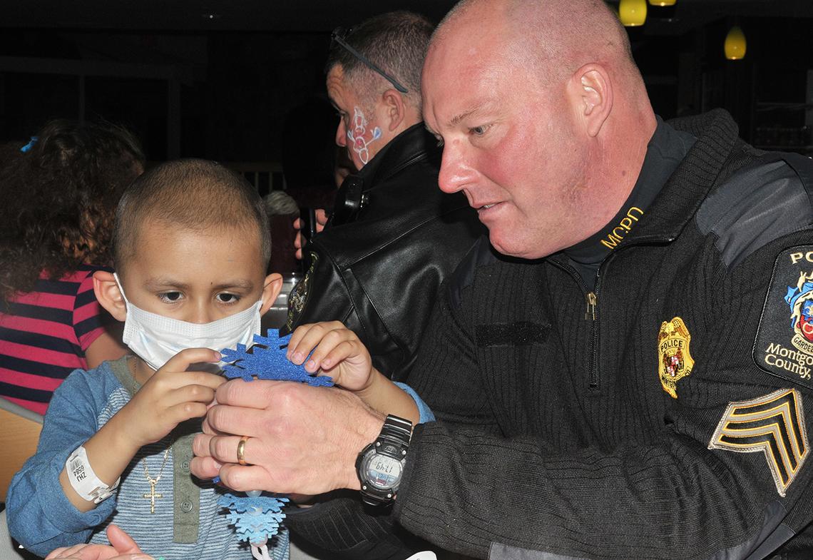 A police officer visits with Children's Inn patient.