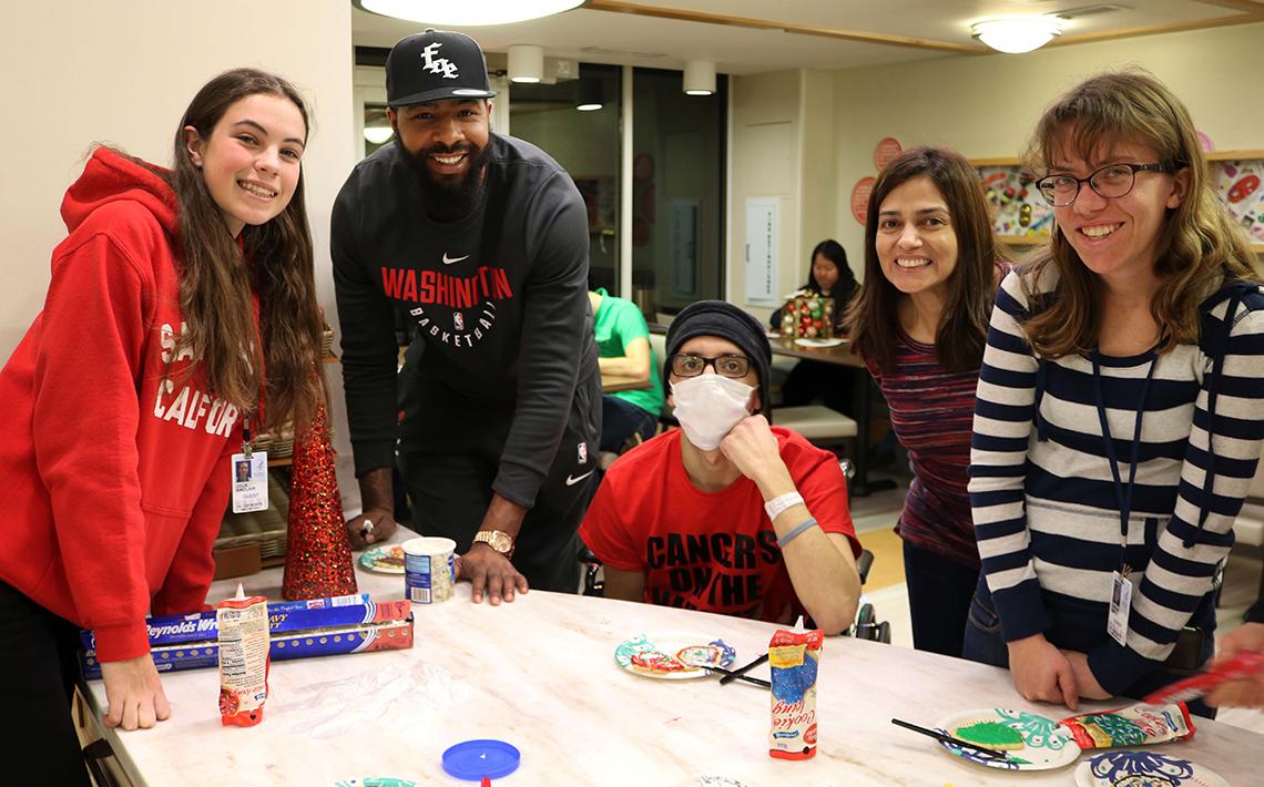 Basketball star decorates cookies at the Children's Inn.