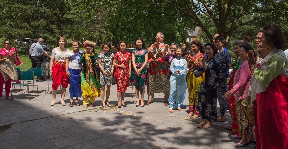 Employees of NIH and AHRQ in colorful attire applaud the audience. 