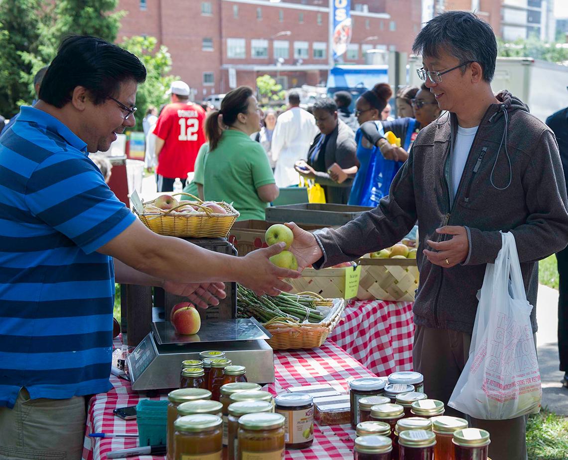 A man purchases apples at the market.