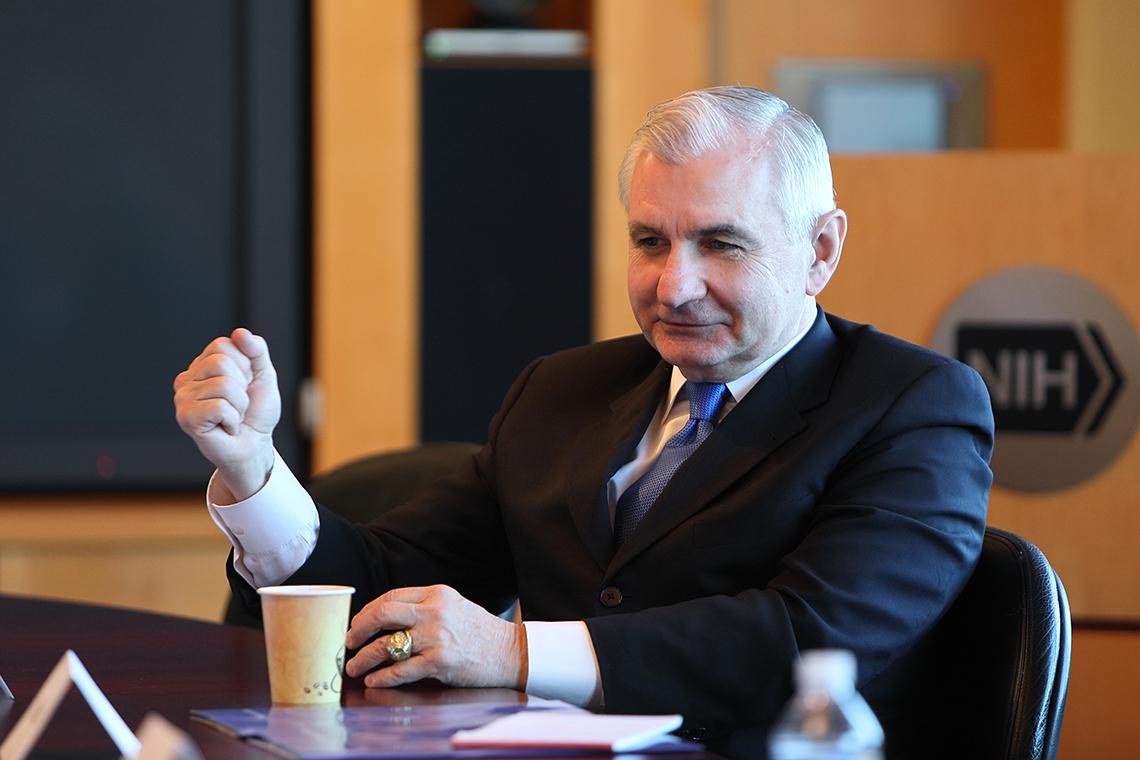 Reed speaking at a conference table.