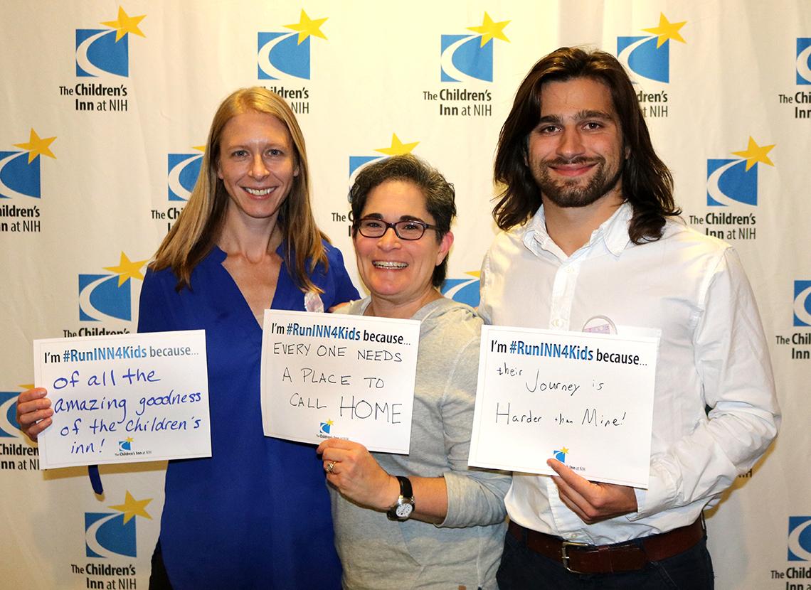 Members of last year’s marathon and 10K teams hold up signs.