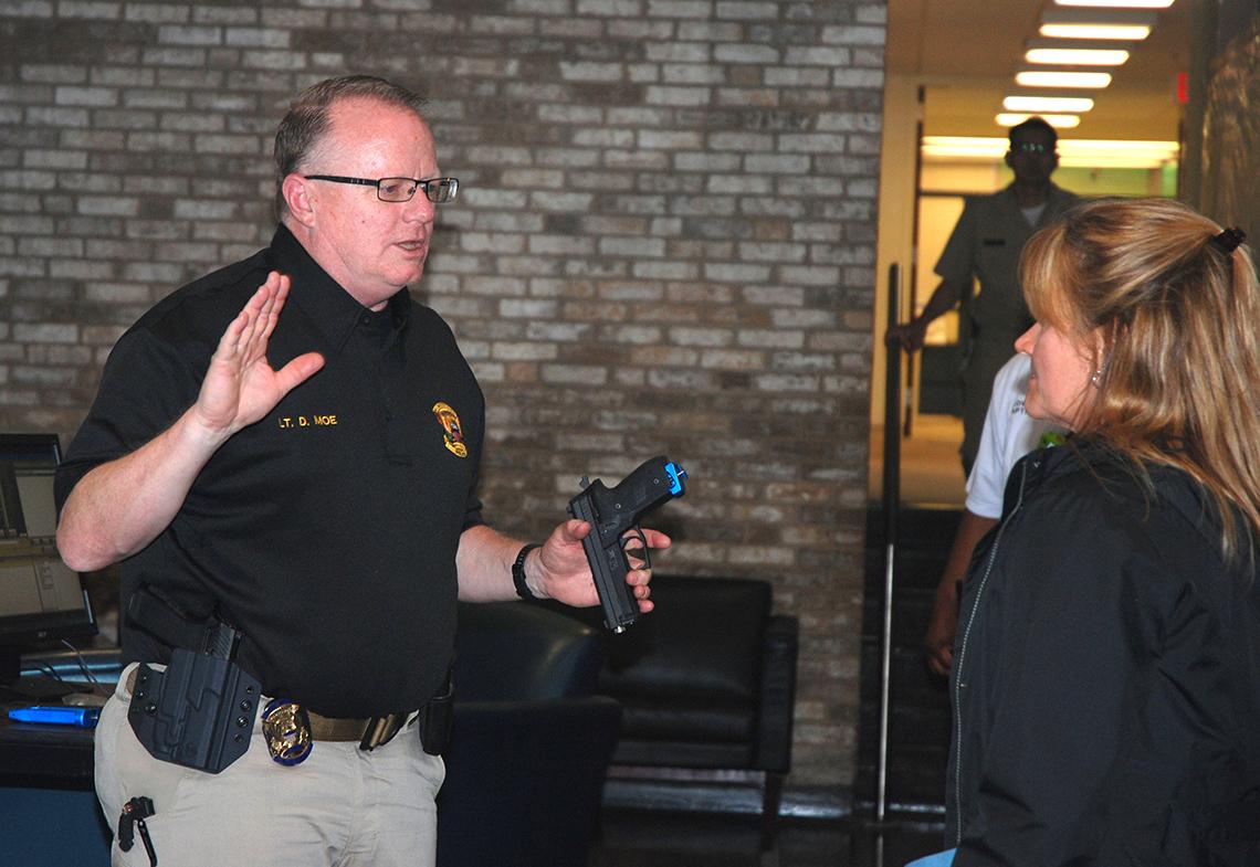 In the Bldg. 31A lobby, Lt. D. Moe of NIH discusses safe weapons handling.