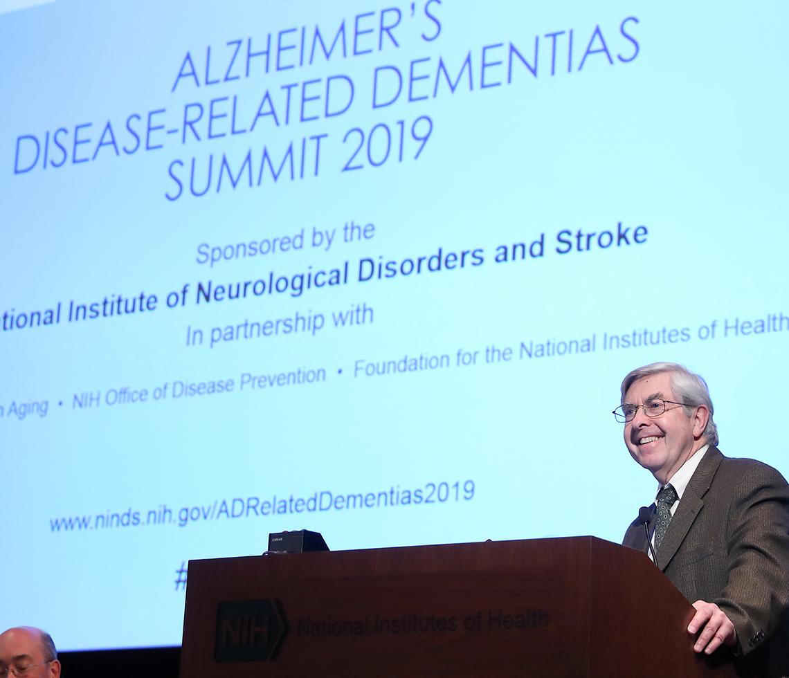 Dr. Koroshetz speaks in front of a screen.